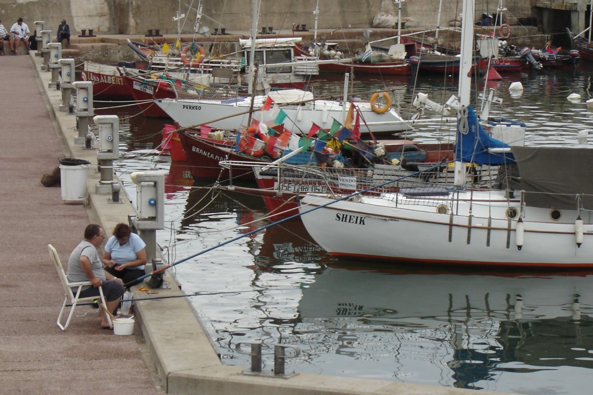 Um casal pescando no Porto de Piriápolis.